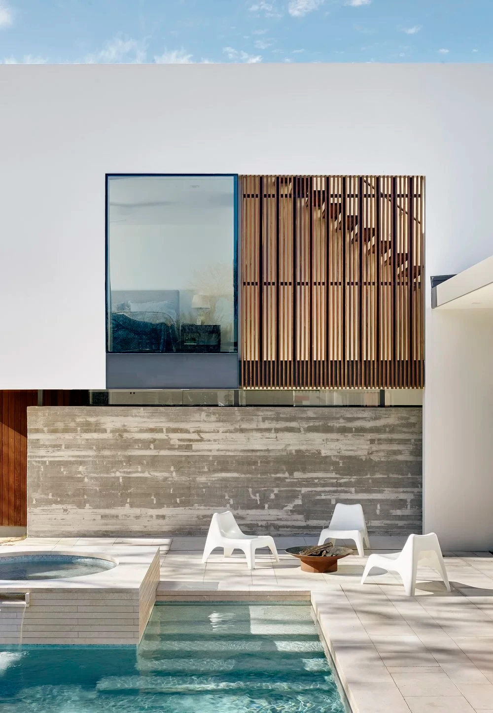 Modern white home with a wood-slat screen above a geometric pool and raised spa in Rollingwood