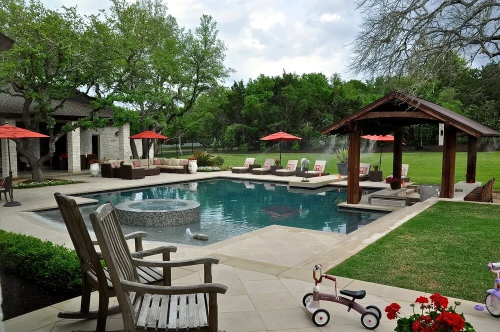 Geometric pool with raised spa, wood pavilion, and lounge chairs on a green lawn in West Lake Hills