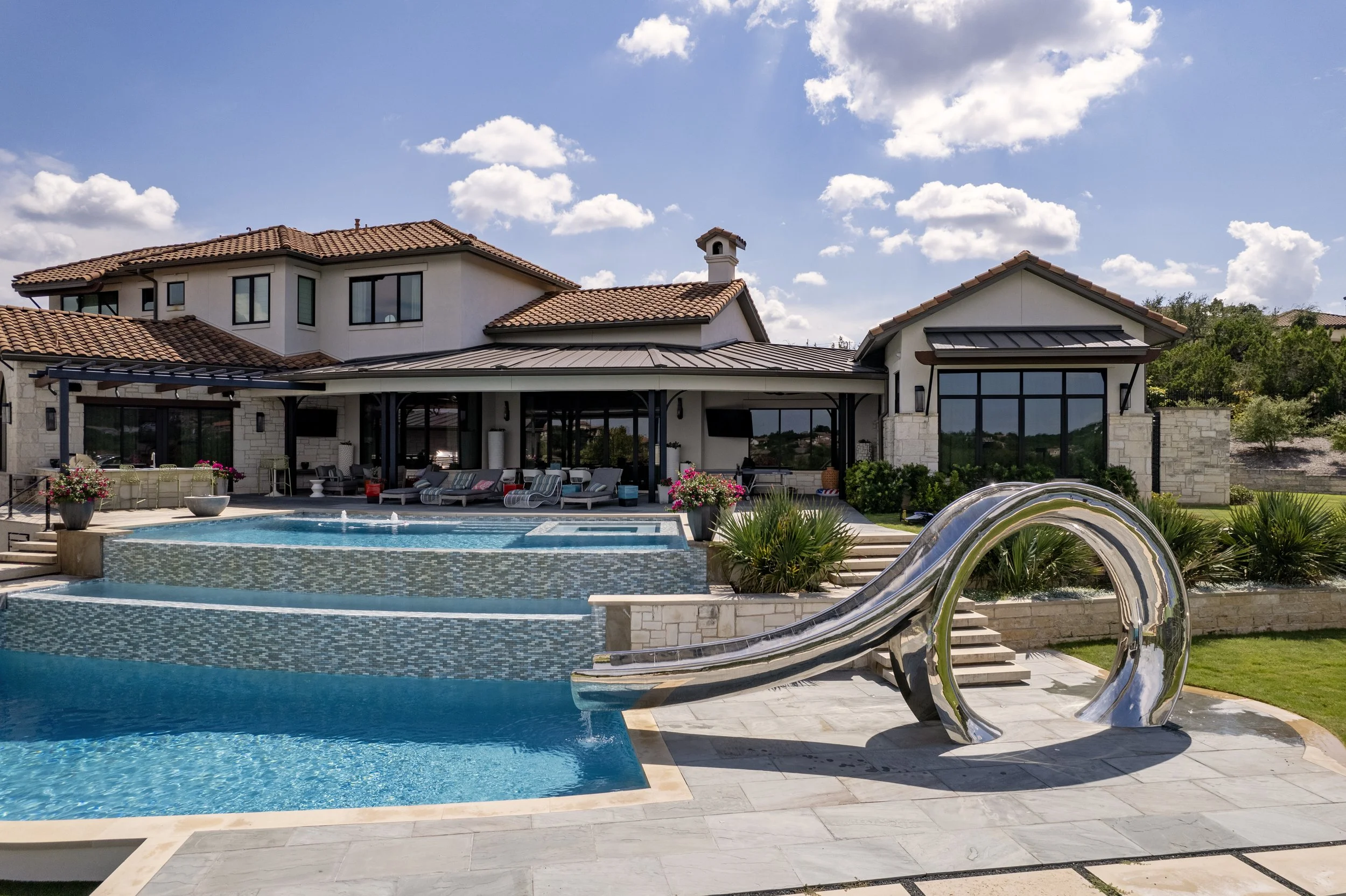 Aerial view of a freeform lagoon style pool on a wooded Austin Hill Country lot