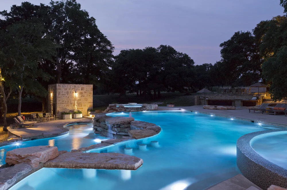 Custom freeform pool with rock features in a natural Austin backyard built by Modern Pools