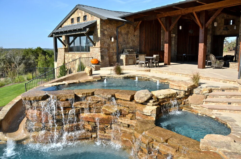 Natural stone grotto waterfall and spillover spa on a custom pool near Austin, Texas